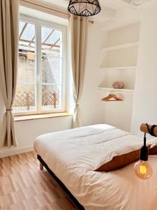 a bedroom with a bed and a window at Le Boudoir in Amboise