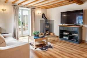 a living room with a couch and a fireplace at The Cottage at Tuffon Hall in Sible Hedingham