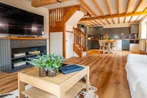 a living room with a couch and a table at The Cottage at Tuffon Hall in Sible Hedingham
