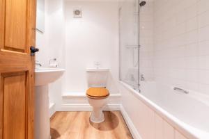 a bathroom with a toilet and a sink and a tub at The Cottage at Tuffon Hall in Sible Hedingham +14 photos