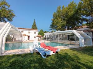 a pool with a chair and a house and a building at Embrujo Andaluz Complejo Rural Órgiva in Órgiva