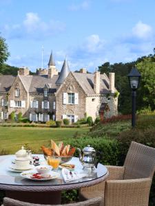 a table in front of a large house at Manoir De Kertalg in Moëlan-sur-Mer