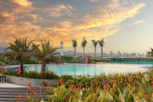 Ein Pool mit Palmen und einer Stadt im Hintergrund in der Unterkunft NUSTAR Hotel Cebu in Cebu City
