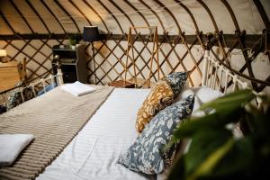 a bed in a yurt with pillows on it at Kelburn Yurts - Bourtrees in Fairlie