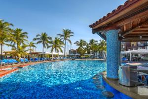 una piscina en un complejo con palmeras en El Cid Marina Beach Hotel, en Mazatlán