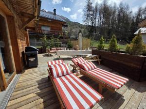 two lounge chairs on a wooden deck with a grill at Chalet La Tanière 14 Pers - piscine chauffée et sauna - Vars Saint Marcellin in Vars