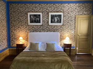 a bedroom with a large bed with two lamps at Demeure Le Ragois de Bretonvilliers - un voyage au cœur du temps - Richelieu in Richelieu