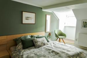a bedroom with a bed and a green wall at Ferienwohnung Otto in Pegnitz