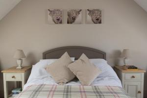 a bed with white sheets and pillows with two night stands at The Loft in Calne