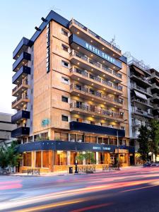 
a city street with a tall building at Savoy Hotel in Piraeus
