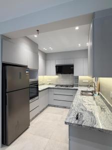 a kitchen with stainless steel appliances and granite counter tops at Chic Stays Modern 3BR in Mountain View ICITY in 6th Of October