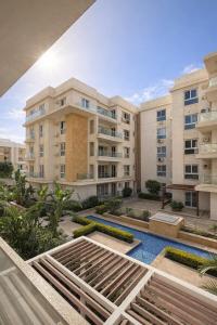 a view of an apartment building with a swimming pool at Chic Stays Modern 3BR in Mountain View ICITY in 6th Of October
