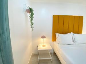 a bedroom with a bed and a table with a plant on it at Vibrant Setúbal II, By Home Match in Setúbal