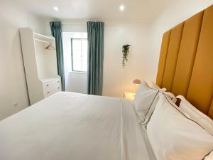a bedroom with a white bed and a window at Vibrant Setúbal II, By Home Match in Setúbal