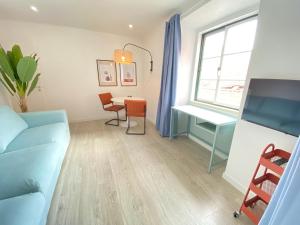 a living room with a table and a desk at Vibrant Setúbal II, By Home Match in Setúbal +16 photos