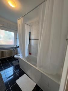 a bathroom with a shower with a tub and a toilet at City Quartier Wedel in Wedel +6 photos