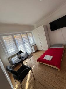 a bedroom with a red bed and a table and chairs at City Quartier Wedel in Wedel