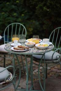 a table with plates of food and glasses of orange juice at St Wenceslas House in Prague