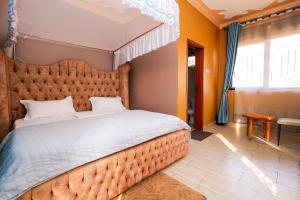 a bedroom with a large bed with an orange wall at EL ROi KADOSHI MOTEL in Kyenjojo