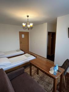 a living room with a couch and a table at Hotel Lanckorona in Jędrzejów