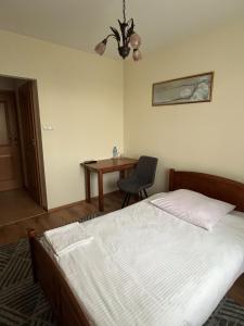 a bedroom with a bed and a table with a chair at Hotel Lanckorona in Jędrzejów