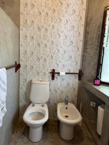 a bathroom with a toilet and a sink at Coastal calm apartment in Watamu