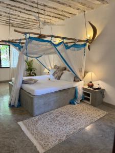 a bedroom with a bed with a mosquito net at Coastal calm apartment in Watamu
