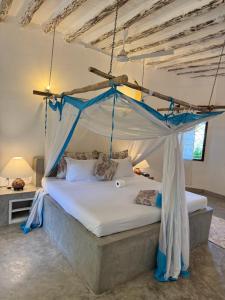 a bed with a canopy in a room at Coastal calm apartment in Watamu