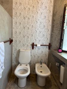 a bathroom with a toilet and a sink at Coastal calm apartment in Watamu +7 photos