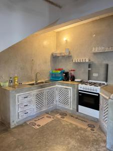 a kitchen with a sink and a stove at Coastal calm apartment in Watamu