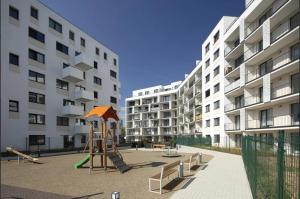 a playground in front of a large apartment building at Stylish Chill Garden Apartment in Bratislava