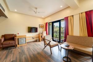 a living room with a couch and a tv at Rosetum Anjuna Goa in Anjuna