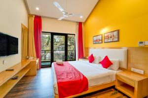 a bedroom with a large bed and a tv at Rosetum Anjuna Goa in Anjuna +36 photos