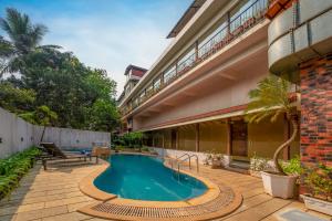 a swimming pool in the courtyard of a building at Rosetum Anjuna Goa in Anjuna