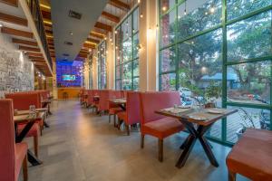 a restaurant with tables and chairs and large windows at Rosetum Anjuna Goa in Anjuna