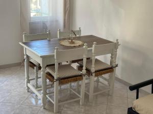 a dining room table with four chairs around it at Casa GIGIA in Sperlonga +1 photo