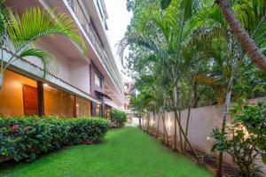 an alley with palm trees next to a building at Rosetum Anjuna Goa in Anjuna