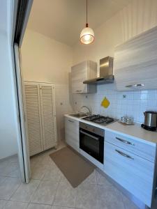 a kitchen with white cabinets and a stove top oven at Casa GIGIA in Sperlonga