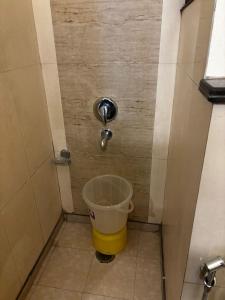 a bucket in the corner of a bathroom at VR Residency 83 in Gurgaon