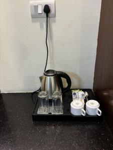 a tea kettle and two cups on a tray at VR Residency 83 in Gurgaon