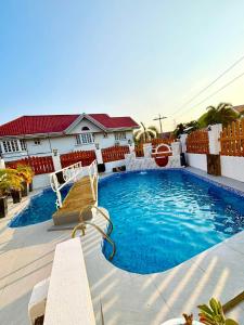 a swimming pool with two chairs and a house at Hotel Adelina Balanga City Bataan in Balanga