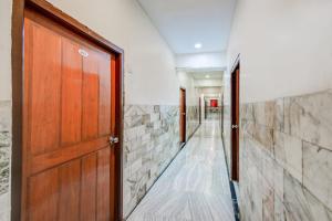 a hallway with a wooden door and stone walls at Super Hotel O MG Road Raniganj Formerly Holiday Hotel in Hyderabad