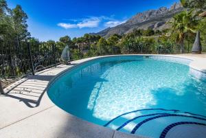 a swimming pool with a bird sitting next to a fence at Casa Les Fremeaux in Altea
