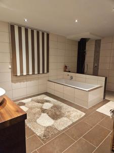 a bathroom with a tub and a large mirror at Die Haas-Villa in Berg