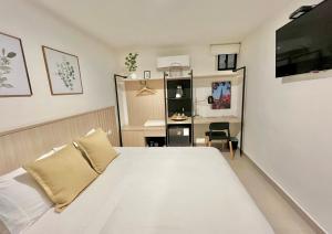 a bedroom with a white bed and a desk at Reset (Hotel-Cafe-Coworking) in Cali