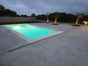 a swimming pool on a patio with palm trees at Casa O OLIVO in Boiro