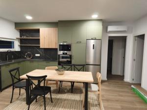 a kitchen with a table and chairs and a refrigerator at Casa O OLIVO in Boiro