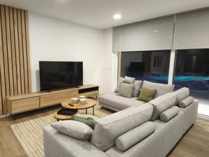 a living room with a couch and a flat screen tv at Casa O OLIVO in Boiro