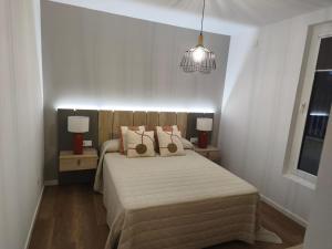 a bedroom with a bed with two pillows on it at Casa O OLIVO in Boiro +2 photos