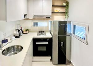 a kitchen with a stainless steel refrigerator and a sink at Reset (Hotel-Cafe-Coworking) in Cali